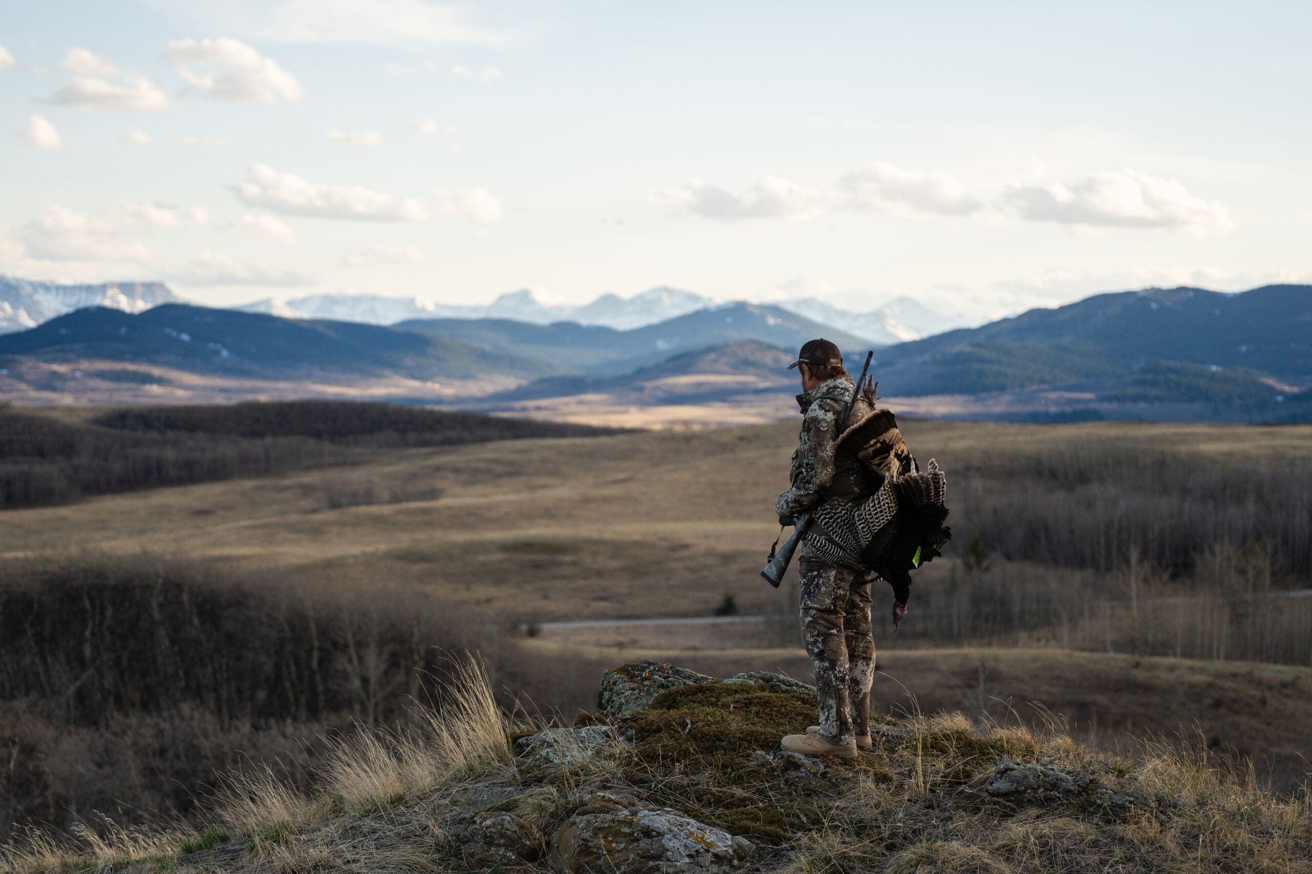 hunter in camo overlooking a field 