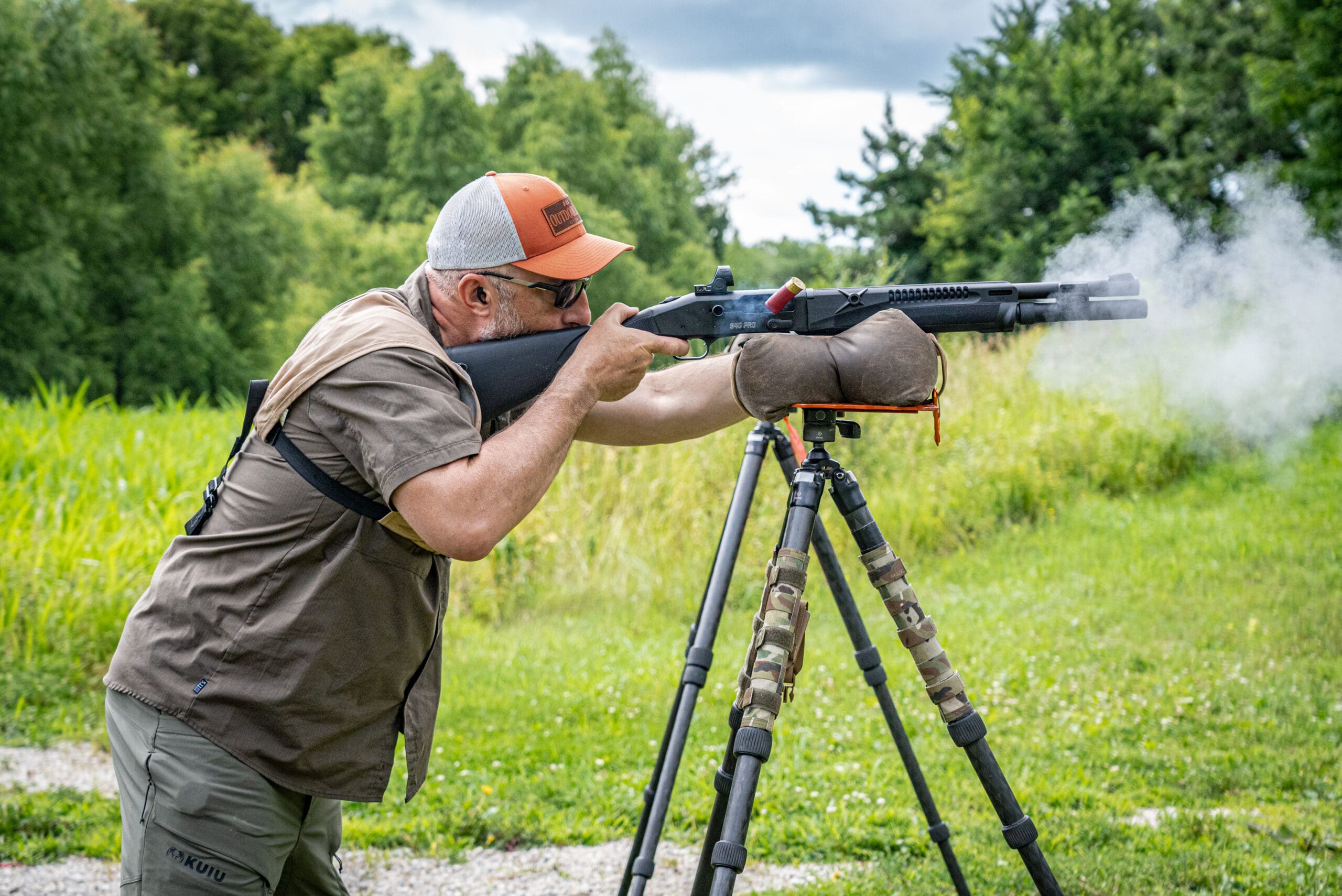 guy shooting a gun on tripod